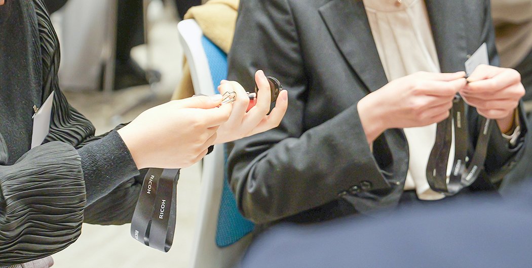 ネックストラップを受け取る新入社員